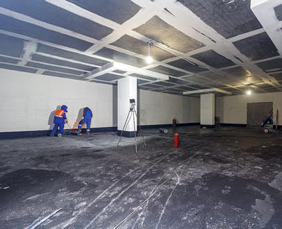 Workers scarifying parking garage concrete