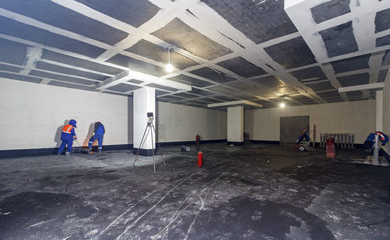 Workers scarifying parking garage concrete